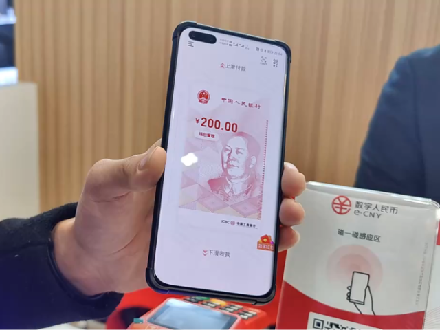 2020年12月11日，在苏州京东之家吾悦广场店，一名收银人员在展示数字人民币支付流程。新华社记者 潘晔 摄